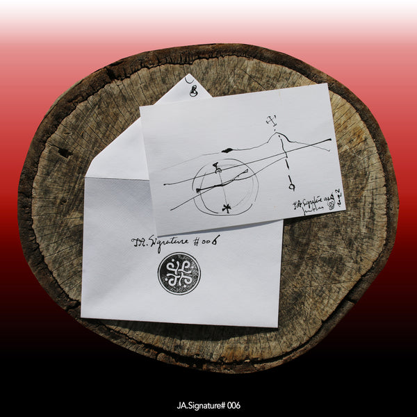JA.SIGNATURE#006 NFT created from the physical collection JA.Signature by James Arax. On the picture : On a log, in the foreground the JA.Signature paper card and below the envelope with the number of the NFT t and james sign (LogoType).