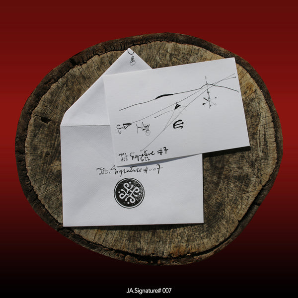 JA.SIGNATURE#007 NFT created from the physical collection JA.Signature by James Arax. On the picture : On a log, in the foreground the JA.Signature paper card and below the envelope with the number of the NFT t and james sign (LogoType).