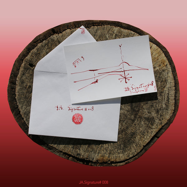 JA.SIGNATURE#008 NFT created from the physical collection JA.Signature by James Arax. On the picture : On a log, in the foreground the JA.Signature paper card and below the envelope with the number of the NFT t and james sign (LogoType).